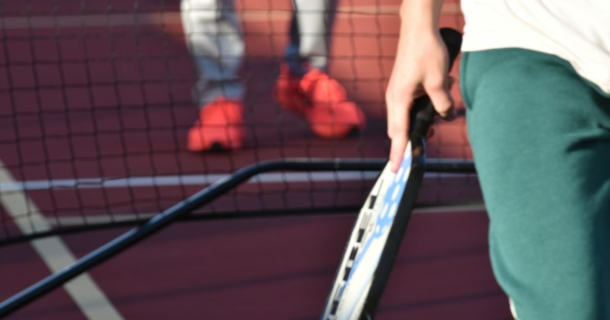 Close-up of a pickleball paddle and player on an outdoor court in Texas