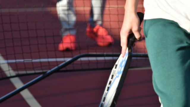 Close-up of a pickleball paddle and player on an outdoor court in Texas