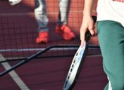 Close-up of a pickleball paddle and player on an outdoor court in Texas