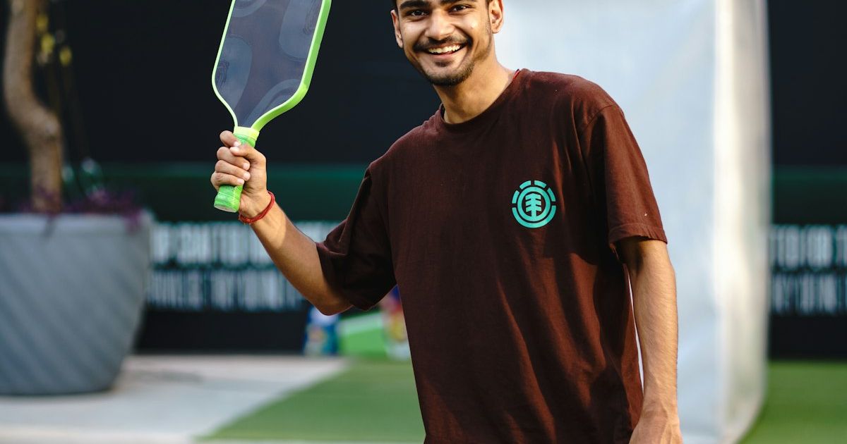 Player holding a pickleball paddle on an outdoor court