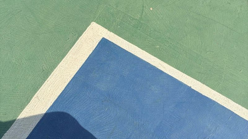 Court shoes on a blue and green outdoor hard court
