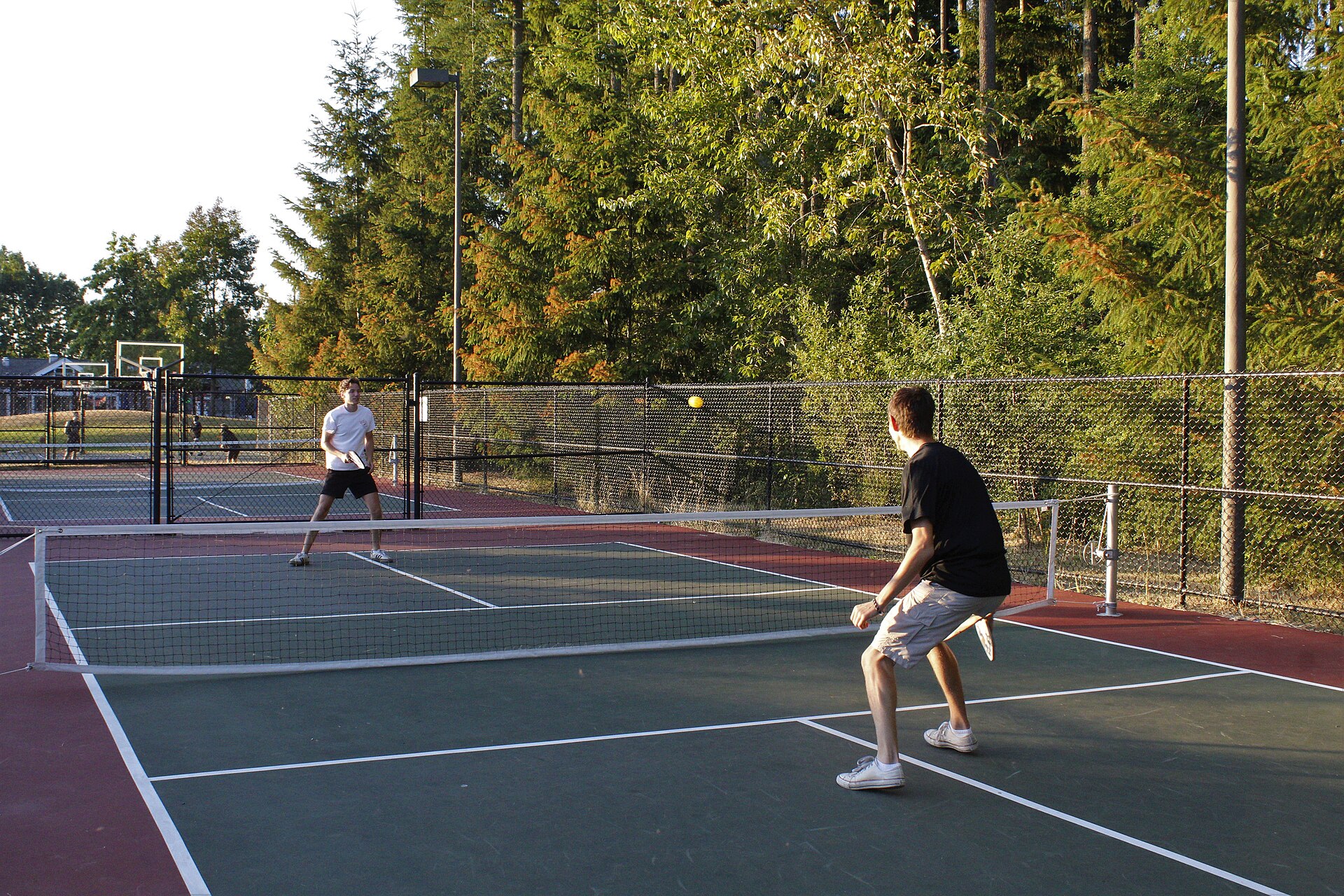 Two players in a rally on an outdoor pickleball court